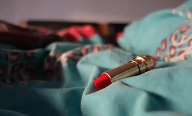 a red lipstick resting on a blue blanket