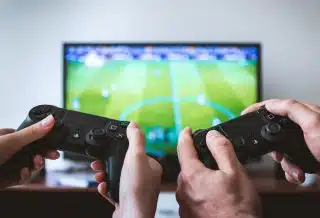 two people playing Sony PS4 game console